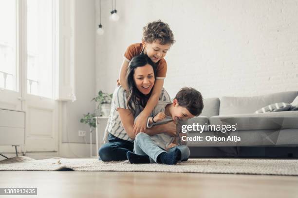 mutter spielt mit söhnen - familie mit zwei kindern stock-fotos und bilder