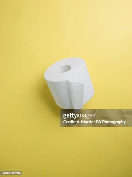 toilet paper roll isolated on a yellow background - toilet paper stock pictures, royalty-free photos & images