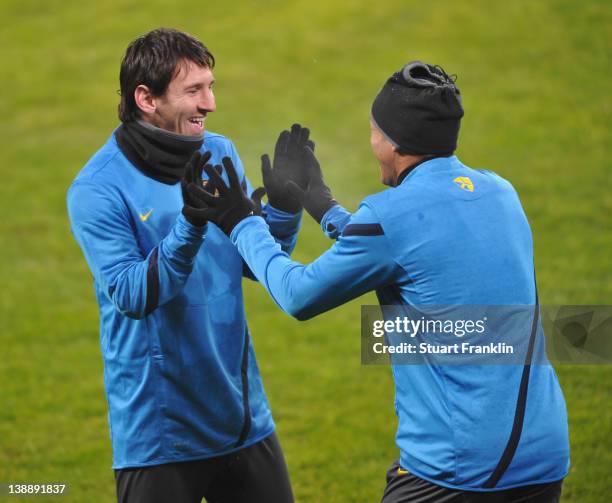 Lionel Messi and Adriano of FC Barcelona joke around during training at the BayArena on February 13, 2012 in Leverkusen, Germany.