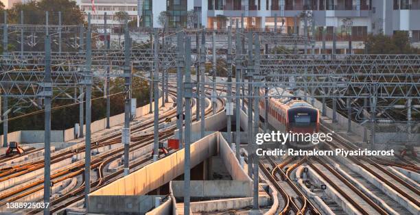 modern high speed red commuter train at the railway station at sunset. turning on train headlights. train at railway platform. industrial landscape. railway tourism - high speed train ストックフォトと画像