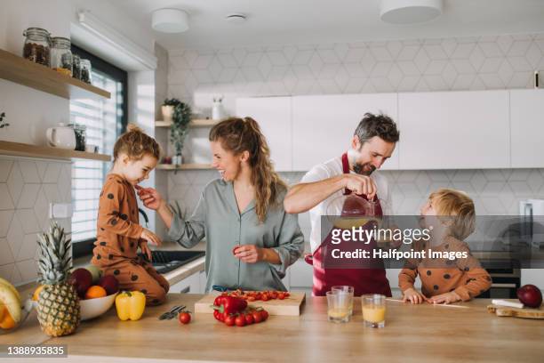 young family with two little children preparing breakfast together in kitchen. - kitchen stock pictures, royalty-free photos & images
