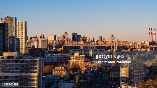 aerial view of long island city, over the residential district to queensboro bridge and roosevelt island. high-res stitched panorama. - skyline stitched composition stock pictures, royalty-free photos & images