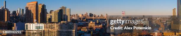 aerial view of long island city, over the residential district to queensboro bridge and roosevelt island. extra-large high-resolution stitched panorama. - queens bridge stock pictures, royalty-free photos & images