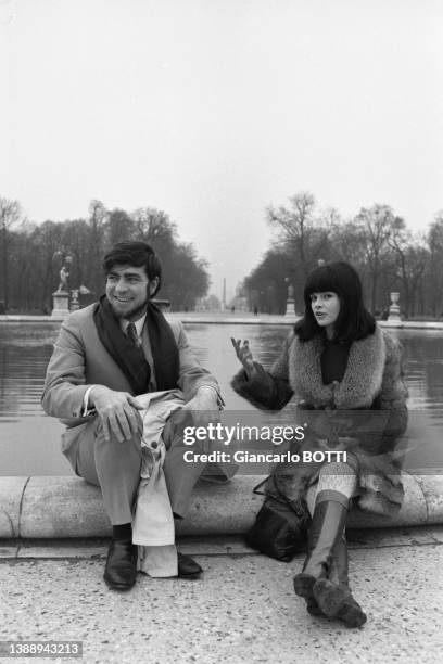 Actrice canadienne Geneviève Bujold et l'acteur britannique Alan Bates dans le jardin des Tuileries à Paris en décembre 1966