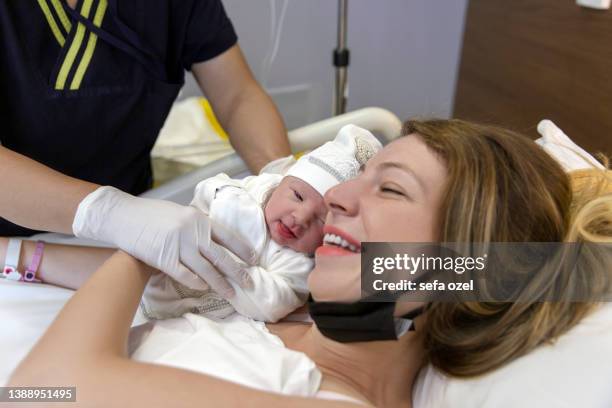 delivery of newborn baby to mother - family photo in the delivery room stock pictures, royalty-free photos & images