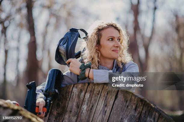 young woman in full gear playing paintball - conflict zone stock pictures, royalty-free photos & images
