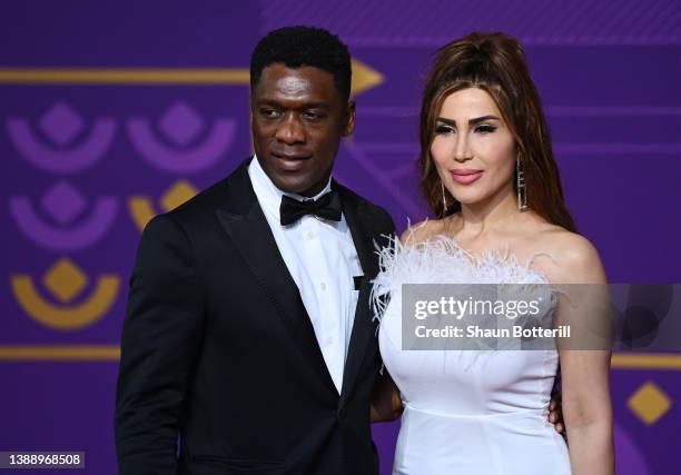 Clarence Seedorf arrives with his wife Sophia Makramati prior to the FIFA World Cup Qatar 2022 Final Draw at the Doha Exhibition Center on April 01,...