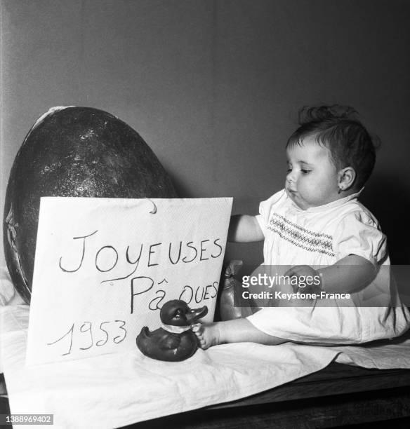 Bébé devant un oeuf de Pâques géant, en avril 1953.