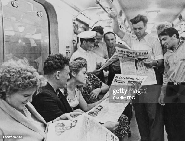 Commuters in a carriage, some reading newspapers reports about Soviet cosmonaut Gherman Titov who had become only the second human to orbit the...