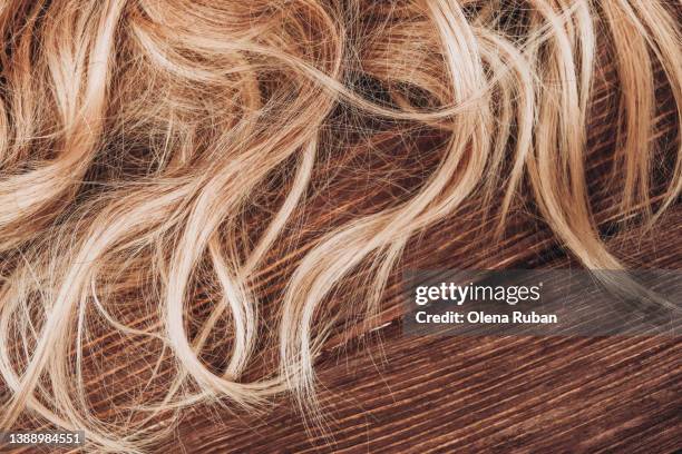 blond hair on wooden surface. - toupee stockfoto's en -beelden