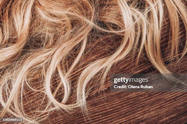 blond hair on wooden surface. - curly wig stock pictures, royalty-free photos & images