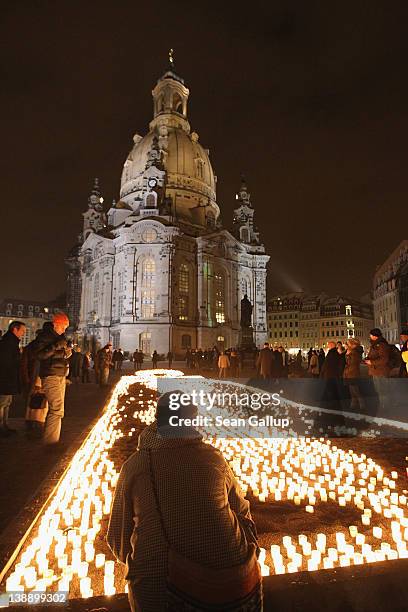 Woman lights candles next to Frauenkirche cathedral to commemorate the victims of the 1945 Allied firebombing of the city on the 67th anniversary of...