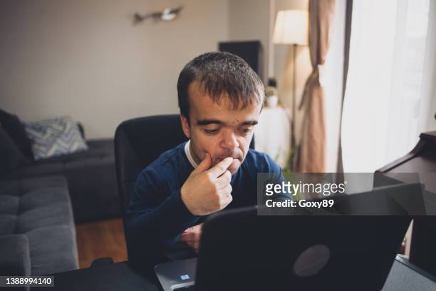 young man with dwarfism working from home - dwarf stock pictures, royalty-free photos & images