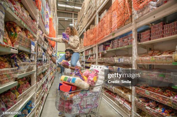 young woman on man's shoulders picking candy - abundance stock pictures, royalty-free photos & images