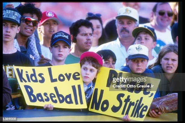 Fan holds up a sign in protest of the baseball strike during a game between the Seattle Mariners and the Oakland Athletics at the Oakland Coliseum in...
