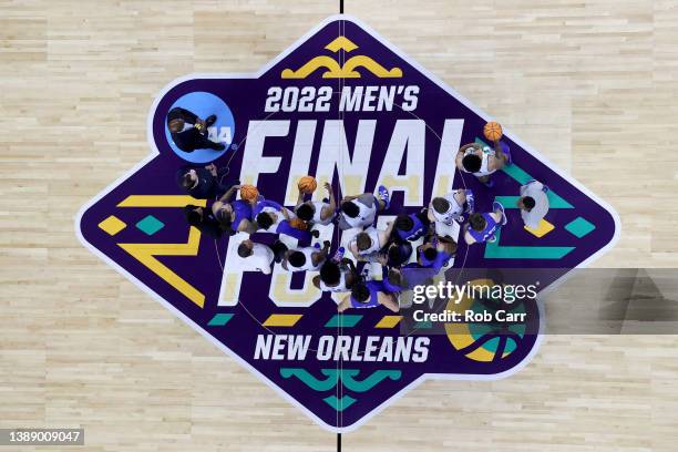 Duke Blue Devils players and coaches pose for photos on the Men's Final Four logo at center court during practice before the 2022 Men's Basketball...