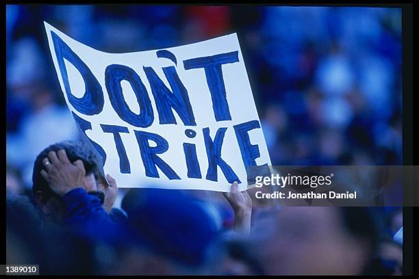 Fans hold up signs in protest of the baseball strike during a game between the San Diego Padres and the Chicago Cubs at Wrigley Field in Chicago,...