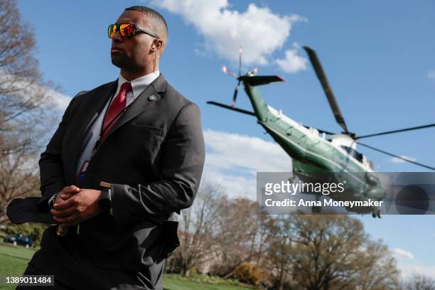 Secret Service Agent looks on as Marine One, carrying U.S. President Joe Biden lifts off from the South Lawn of the White House on April 01, 2022 in...