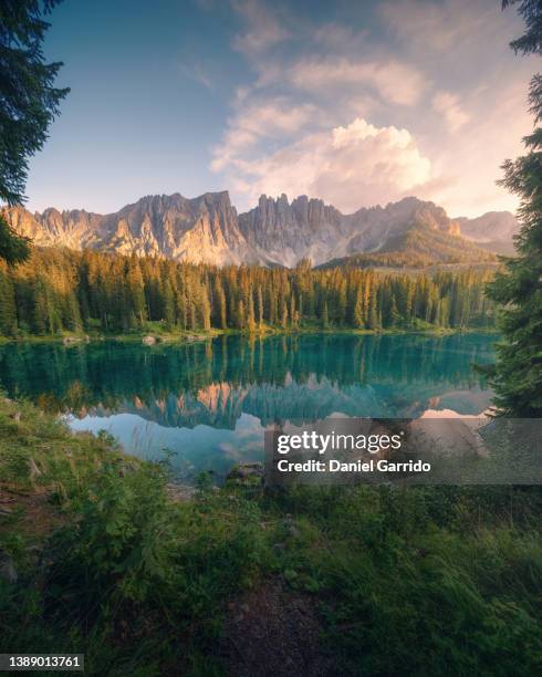 sunset at lago di carezza with a beautiful reflection, landscapes of the italian dolomites, landscape photography - lago de carezza fotografías e imágenes de stock