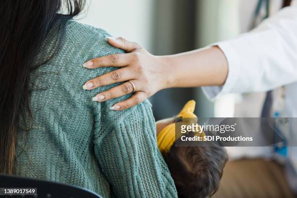 unrecognizable person touches a mother's shoulder - alternative therapy bildbanksfoton och bilder