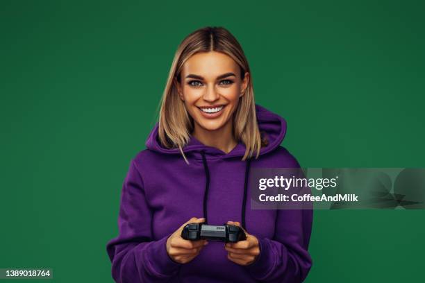 woman holding joystick and playing - hooded top stock pictures, royalty-free photos & images