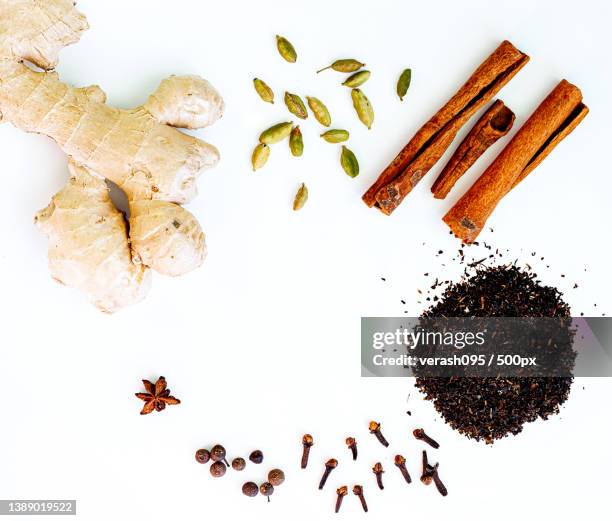 ingredients for indian masala tea on white background - koriander stockfoto's en -beelden