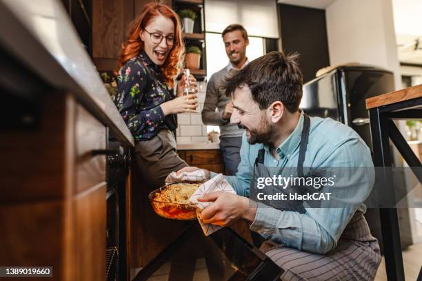 homme joyeux préparant de la nourriture pour ses amis - party host stock photos et images de collection