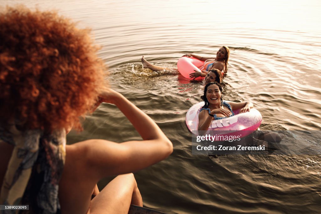 Group of female friends enjoying a summer day swimming at the lake.