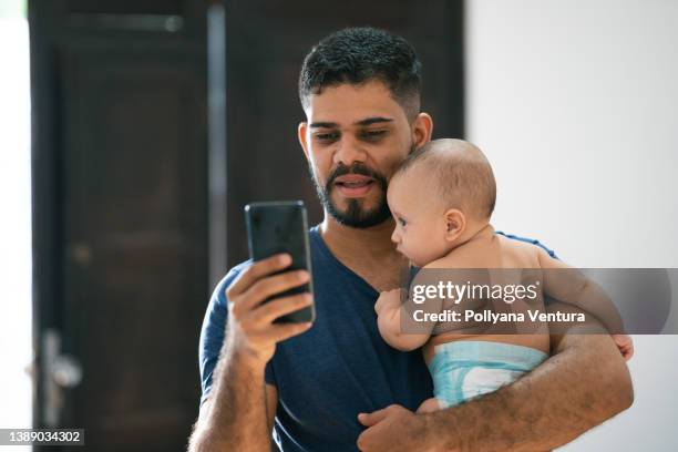 father holding baby and making video call - dad calling stock pictures, royalty-free photos & images