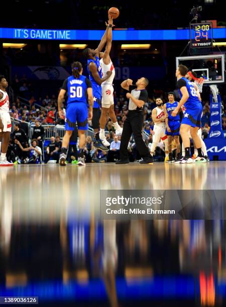 Scottie Barnes of the Toronto Raptors and Mo Bamba of the Orlando Magic jump ball during a game at Amway Center on April 01, 2022 in Orlando,...