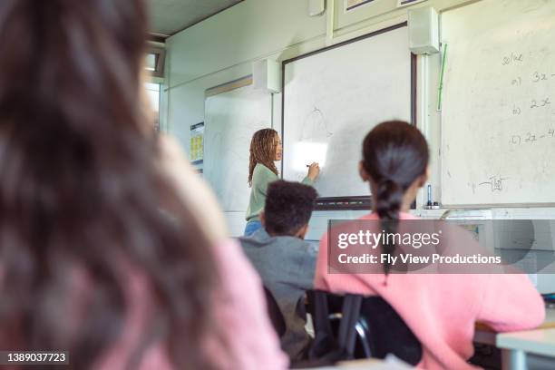 teacher writing on whiteboard while teaching elementary age students - middle school math stock pictures, royalty-free photos & images