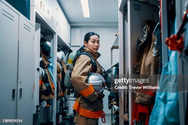 portrait of a female firefighter wearing her protective equipment - 消防士　日本 ストックフォトと画像