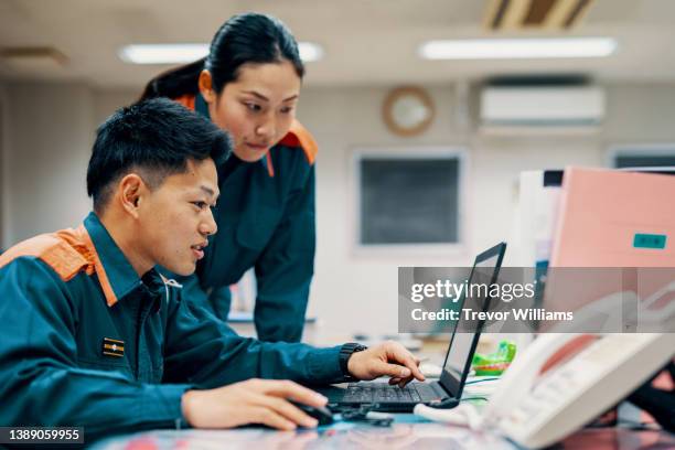 female firefighter helping another male firefighter - pianificazione di emergenza foto e immagini stock