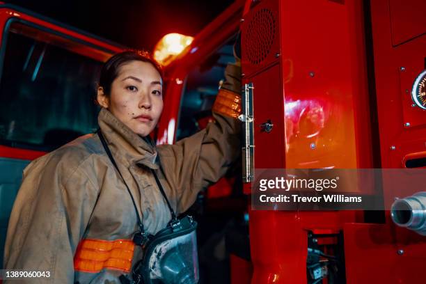 portrait of a female firefighter wearing her protective equipment - 消防士　日本 ストックフォトと画像