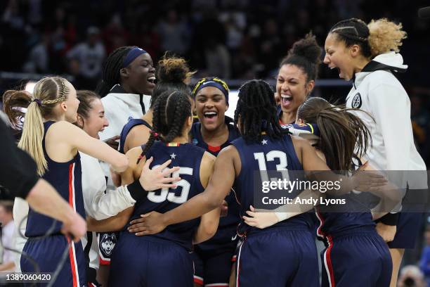 The UConn Huskies celebrate after defeating the Stanford Cardinal 63-58 during the 2022 NCAA Women's Final Four semifinal game at Target Center on...