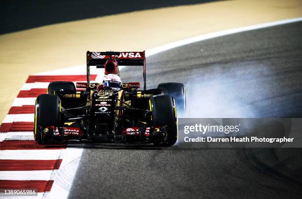 French Lotus Formula One racing team racing driver Romain Grosjean driving his E22 racing car at speed and braking hard for Turn 10 of the circuit...