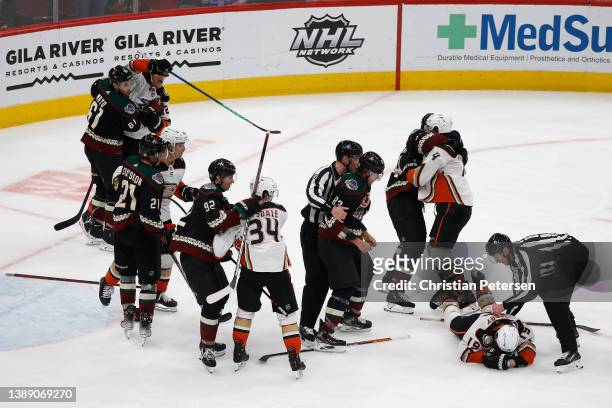 Jay Beagle of the Arizona Coyotes is held back by linesman Jonathan Deschamps after a fight with Troy Terry of the Anaheim Ducks during the third...
