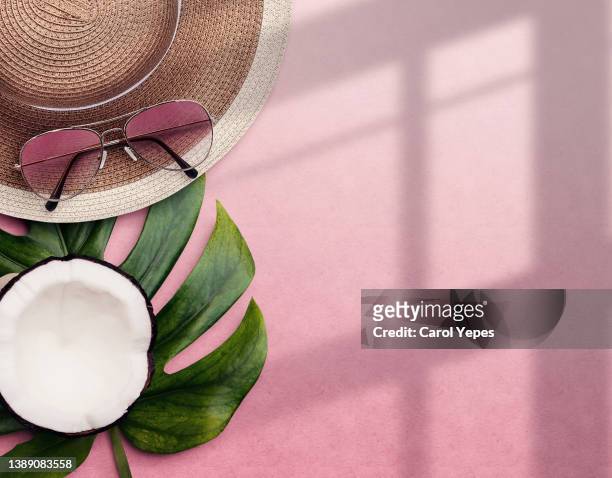 top view summer composition with sun hat, sun glasses, coconut in pink background and space for copy - bolsa de cor creme fotografías e imágenes de stock