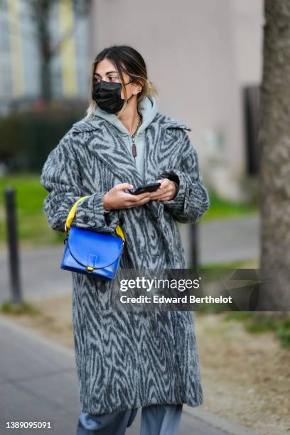 Guest wears a gray hoodie zipper sweater, a dark and pale gray zebra print pattern long fluffy coat, a royal blue electric varnished leather with...