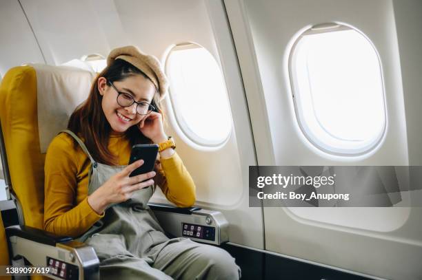 happiness asian passenger sitting on a seat on plane. ready for traveling by plane. - aircraft wifi fotografías e imágenes de stock