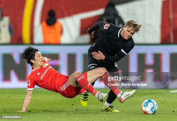 Timo Huebers of 1. FC Koeln is tackled by Genki Haraguchi of 1.FC Union Berlin during the Bundesliga match between 1. FC Union Berlin and 1. FC Koeln...