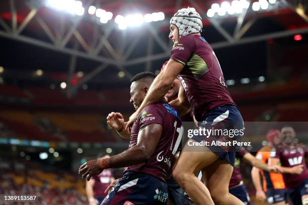 Filipo Daugunu of the Reds celebrates with team mates after scoring a try during the round seven Super Rugby Pacific match between the Queensland...