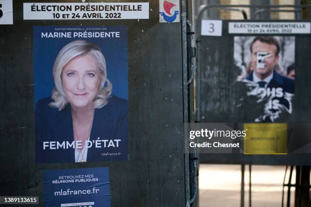 An official campaign poster of Marine Le Pen, leader of the far-right Rassemblement national and a damaged and torn official campaign poster of...