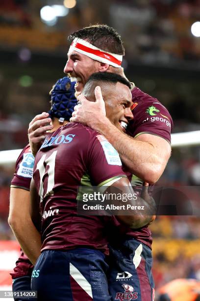 Filipo Daugunu of the Reds celebrates with team mates after scoring a try during the round seven Super Rugby Pacific match between the Queensland...