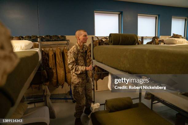 Member of the US Marine Corps stands in his barracks after taking part in the traditional Eagle, Globe and Anchor medal ceremony March 26, 2022 at...