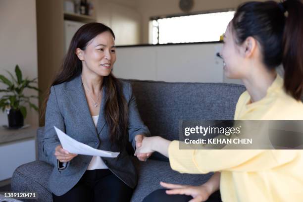 asian banker working on a contract with a young house buyer - legal assistance stock pictures, royalty-free photos & images