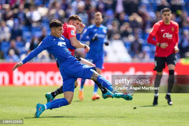 Mathias Olivera of Getafe CF competes for the ball with Giovanni Gonzalez of RCD Mallorca during the LaLiga Santander match between Getafe CF and RCD...