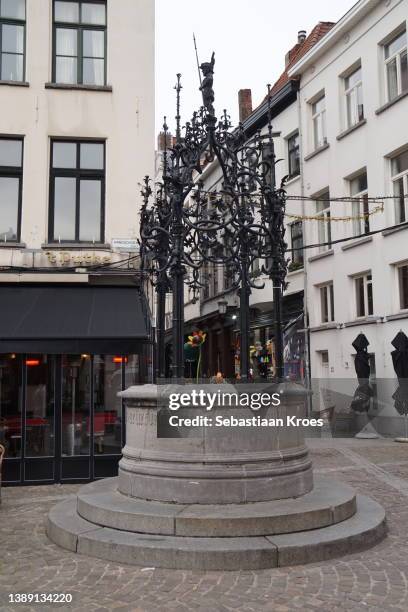 historic water well at the handschoen markt square, antwerpen, belgium - handschoen photos et images de collection