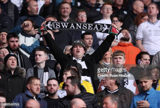 Swansea City fan holds up a scarf prior to kick off of the Sky Bet Championship match between Cardiff City and Swansea City at Cardiff City Stadium...