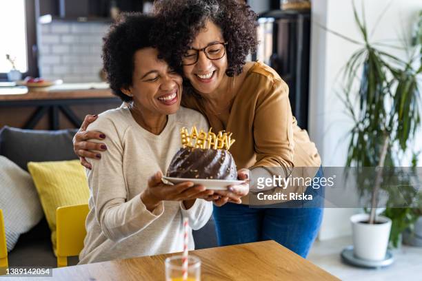 latin american lesbian woman celebrating her birthday at home - holding birthday cake stock pictures, royalty-free photos & images